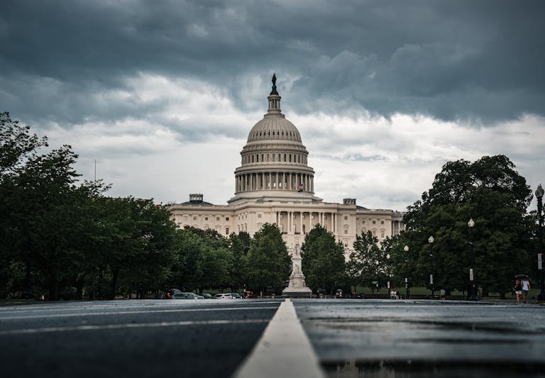 Dramatic view of the US Capitol under cloudy skies, showcasing Washington DC's historic architecture.