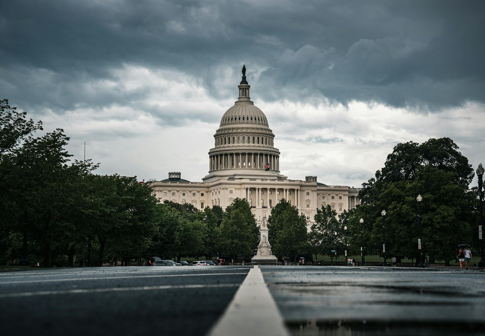 Dramatic view of the US Capitol under cloudy skies, showcasing Washington DC's historic architecture.